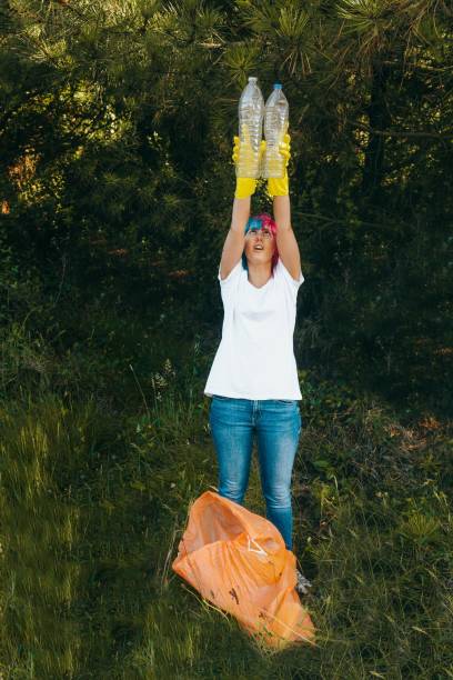 istock Female wearing gloves holding recyclable plastic bottles - plastic pollution concept 1439414940