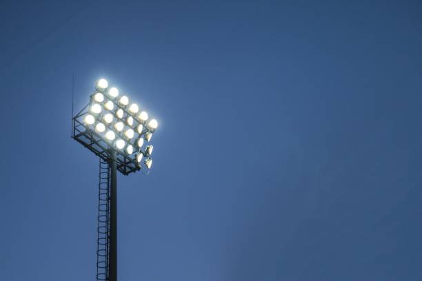 istock Low angle closeup shot of stadium lights under a dark blue sky 1439415012