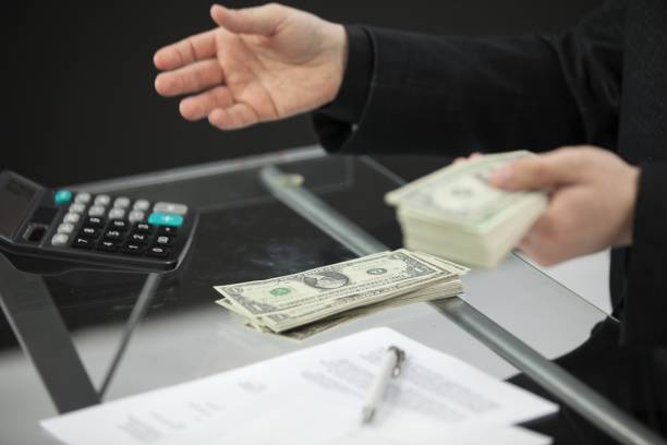 istock Counting the money behind his desk 1439416680