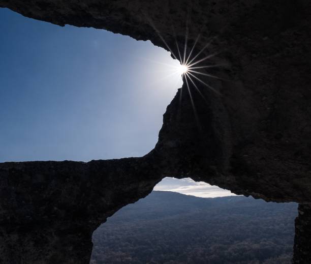 istock Sun shining through the cave underneath which there is a forest 1439417361