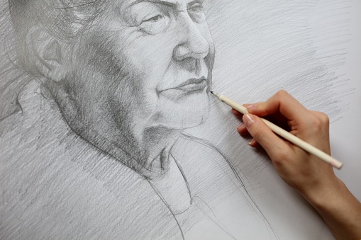A closeup shot of a woman's hand drawing a senior woman