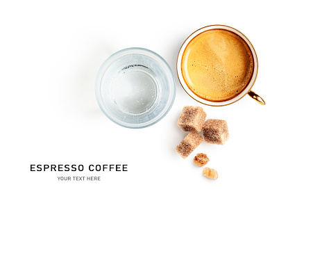 Espresso coffee, glass of water and brown sugar cubes creative layout isolated on white background. Beverage composition. Healthy eating food concept. Flat lay, top view. Design element
