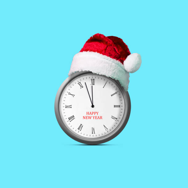 istock Clock in a Santa Claus hat. Isolated on blue background. Design element. Christmas background. Festive 1439420405