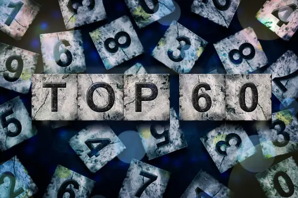 Photo of Top 60, words, above different numbers, on a dark blue background, with different letters. Alphabet on stone blocks.Rating. Rating concept.