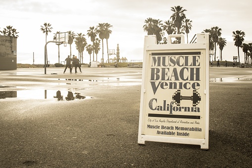 Venice Beach, CA, United States – March 03, 2016: Muscle Beach at Venice Beach California basketball court after rain with people playing basketball.