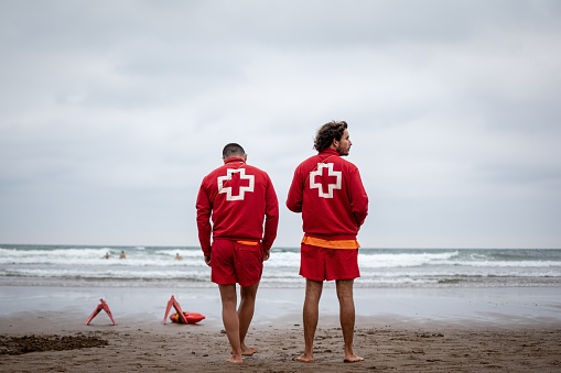 Sopela, Spain – August 24, 2019: Color photo of two lifeguards at the beach, with a strong red to it