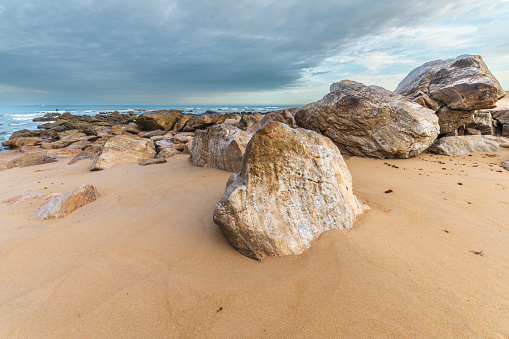Rocks polished by waves of Atlantic Ocean on sandy beach. Sables d'olonne, France.