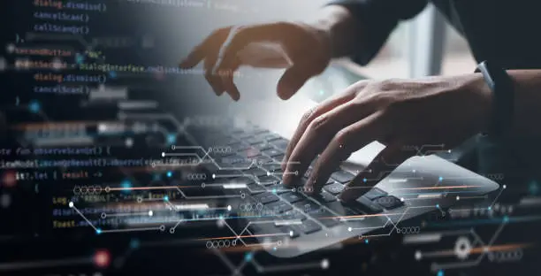 Photo of Digital technology, software development concept. Coding programmer working on laptop with circuit board and javascript on virtual screen