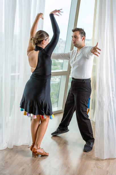 Full body portrait of two young elegant people feelings dancing isolated on white color background.