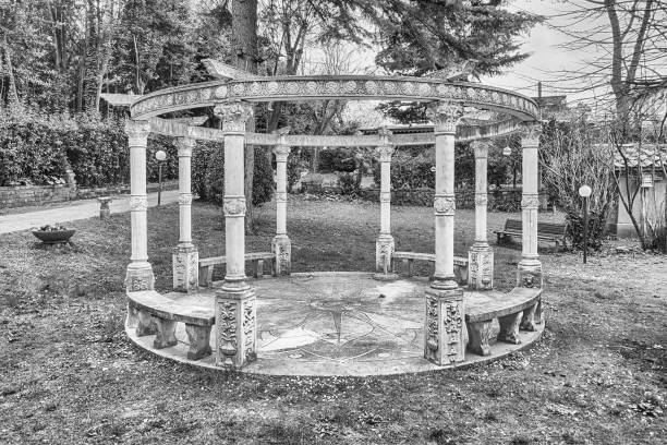 Black and white photo of a bench in a garden