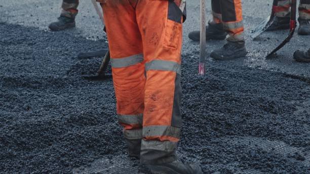 istock Roadwork Physical Workers in Protective Work Wear Repairing Street Tarmac Surface with Hot Asphalt 1439432037