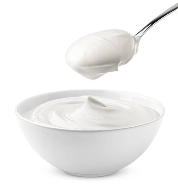 sour cream in bowl and spoon, mayonnaise, yogurt, isolated on white background, clipping path, full depth of field stock photo