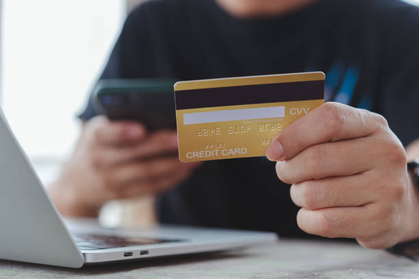 istock Online shopping e-commerce or internet banking concept.Man hand holding credit card and using laptop.Business finance payment and accounting. 1439433845