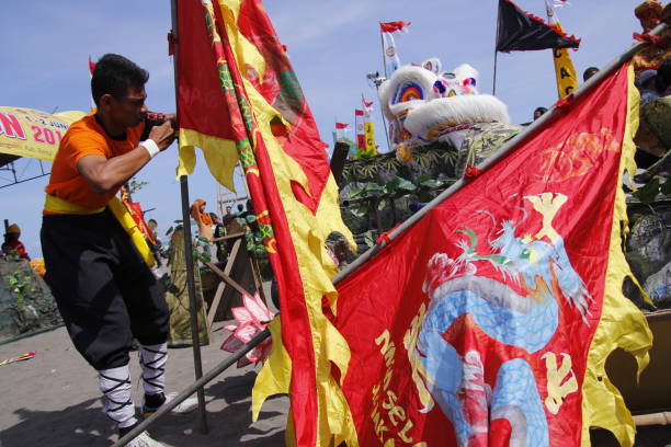 un uomo si prepara a mettere una bandiera con l'immagine di un drago al festival del drago - settimana della moda cinese foto e immagini stock