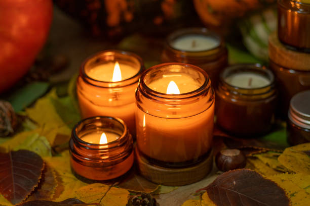 Soy candles burn in glass jars. Tree leaves. Comfort at home. Candle in a brown jar. Scent and light. Scented handmade candle. Aroma therapy. Autumn mood. Cozy home decor in fall. Festive decoration. las velas de soja arden en frascos de vidrio. hojas de árbol. comodidad en casa. vela en un frasco marrón. aroma y luz. vela perfumada hecha a mano. aromaterapia. estado de ánimo otoñal. acogedora decoración del hogar en otoño. decoración festiva