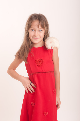 studio portrait of a girl in a red dress with a white domestic rat
