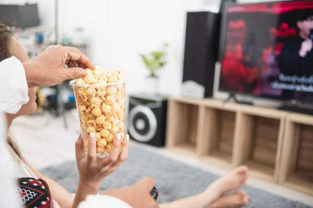 istock Eating popcorn while watching TV entertainment and online streaming. 1439441658