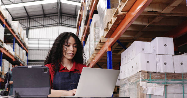 Warehouse workers are sitting at work checking products in the warehouse. Product information from the database in the laptop. shelf in the factory. professional work stock photo