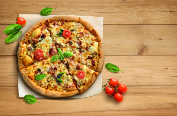 istock Hot supreme pizza on wooden table with tomatoes and basil flat lay. 1439444906