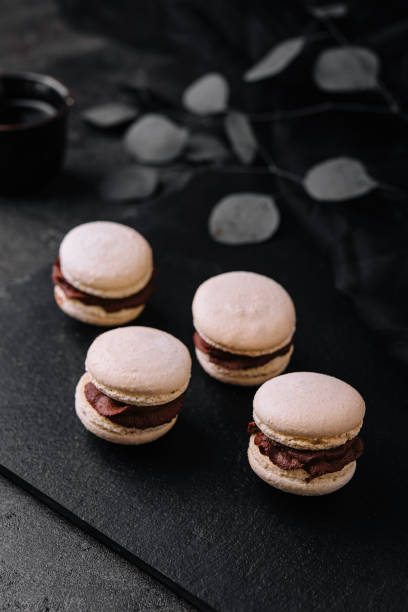 istock Caramel macarons with chocolate filling on black stone 1439446560