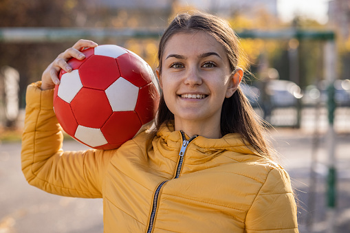 Smiling woman posing with soccer ball