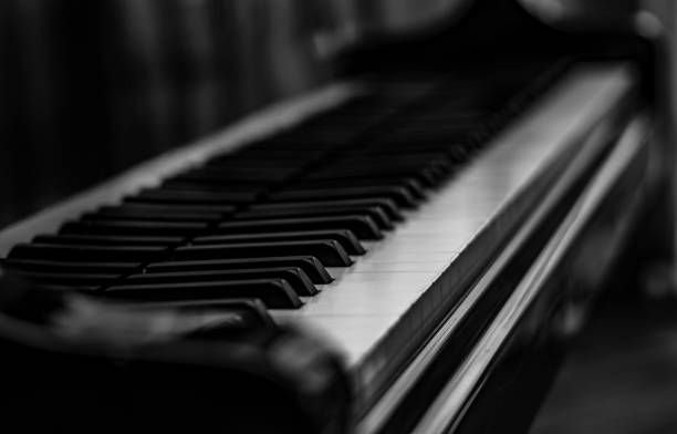 istock Closeup greyscale shot of a piano on a blurred background 1439452990