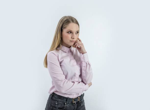 istock Woman with a concerned look behind a white background 1439453026