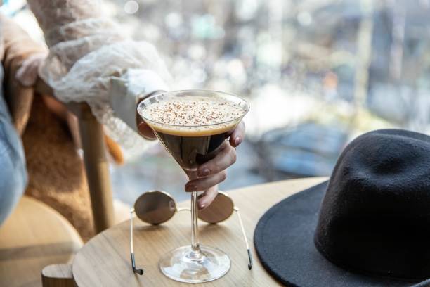 woman's hand picking a martini glass filled with delicious chocolate coffee martini - espresso women cup drink imagens e fotografias de stock