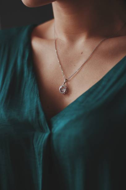 closeup shot of a female wearing a beautiful silver necklace with a diamond pendant - gold jewelry necklace locket imagens e fotografias de stock