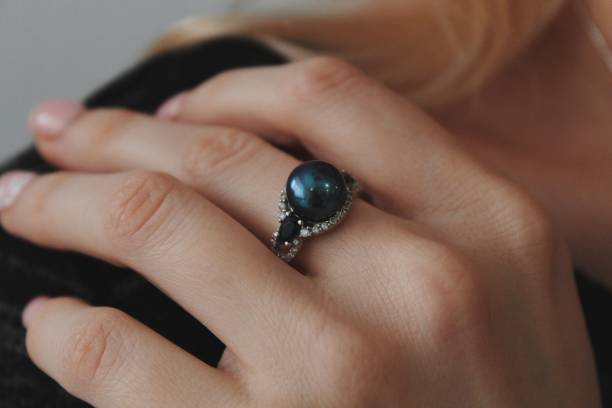 primer plano de una mujer con un hermoso anillo con una perla negra - pearl necklace earring jewelry fotografías e imágenes de stock