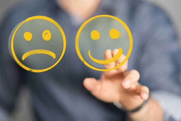 istock A Hand is selecting a happy mood smiley. In front of an empty room 1439455980