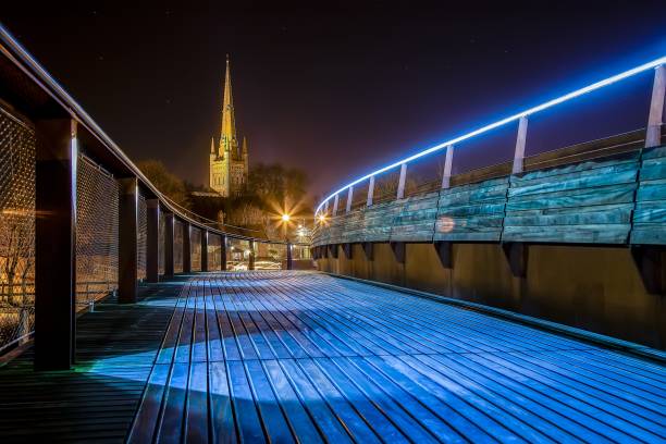 cattedrale di norwich di notte con una lunga esposizione dal jarrold foot bridge, norwich, inghilterra - european architecture flash foto e immagini stock