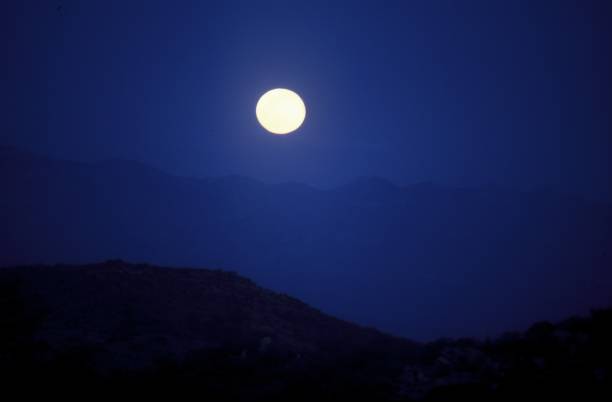 istock Full moon in the dark blue sky over the desert 1439457895