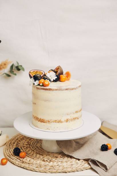 istock White cake with berries and passionfruits with plants behind a white background 1439458871
