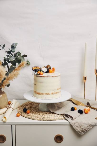 istock White cake with berries and passionfruits next to a plant behind a white background 1439458889