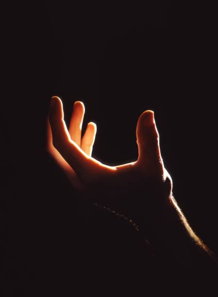 istock Vertical shot of a person's hand with a black background 1439458938