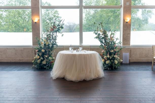 istock Small table with tulle and two floral compositions in the wedding hall 1439459406