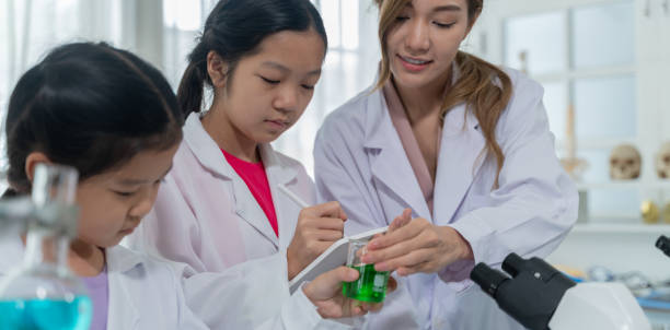 istock Asian kid learning with scientist in the laboratory. Physical examination and science education class. 1439459943