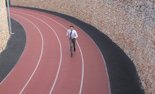 A view of a male wearing a shirt and tie while running in the running field