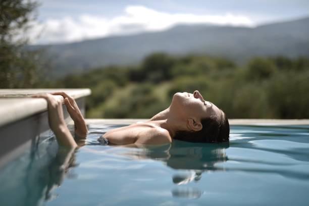 istock Woman with closed eyes leaning her head into the pool 1439462258
