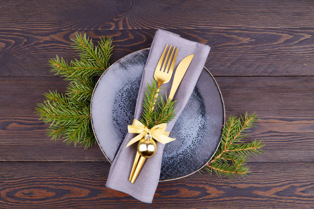 istock Christmas table setting. Vintage plate, silverware, fir branches on a dark wooden background. 1439462291