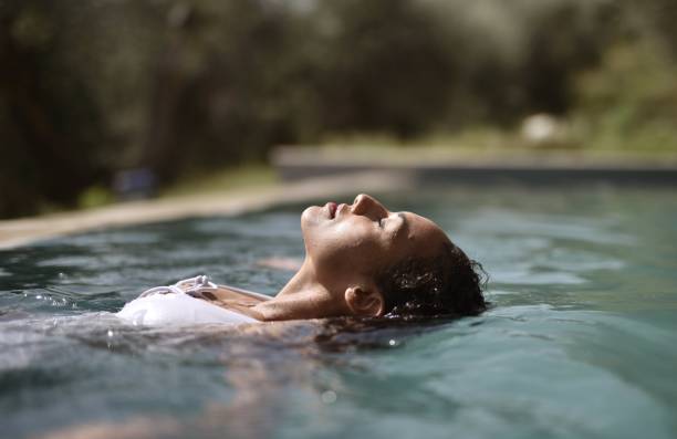 istock Woman with closed eyes leaning her head into the pool 1439462516
