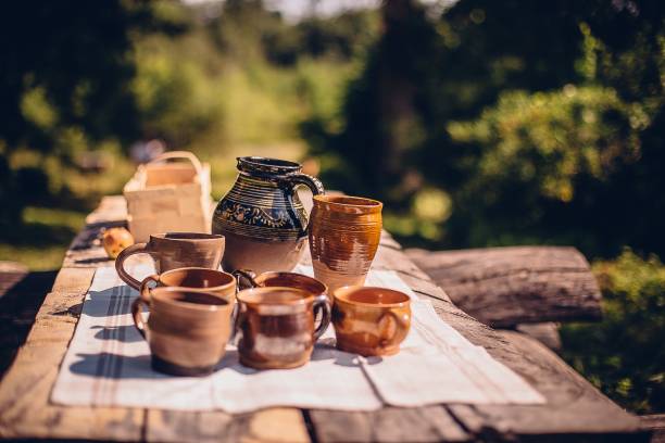 屋外の木製テーブルの上の土鍋とカップのクローズアップショット - plate ceramics pottery isolated ストックフォトと画像