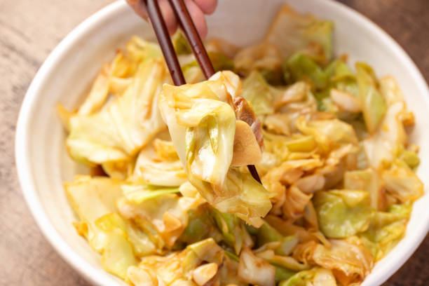 istock Stir-Fried Asian style Cabbage with soy sauce and rice wine picked with chop sticks 1439470129