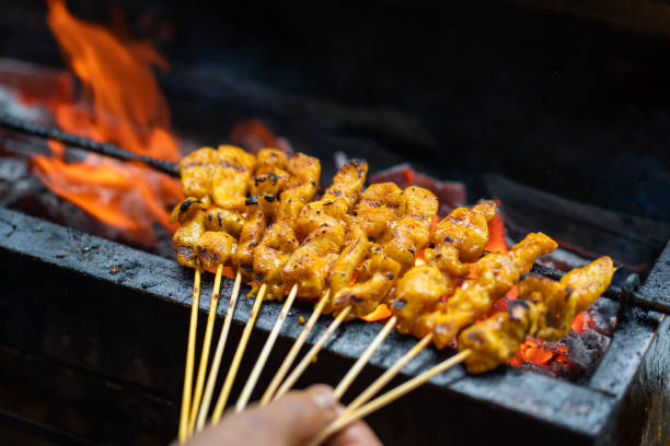 Cropped image of man preparing satay on barbecue stock photo