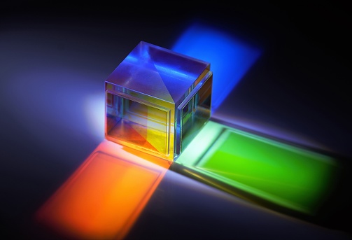 multicolored rays of light reflected by a crystal cube
