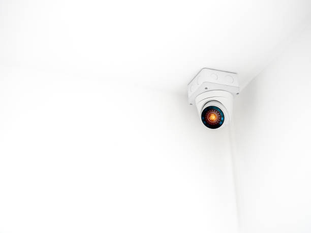 istock The digital eye technology on white security CCTV Camera or surveillance operating on ceiling in the corner room in the white wall building background with copy space. 1439474834