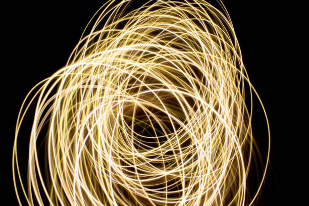 istock Abstract yellow light swirl on black background 1439476409