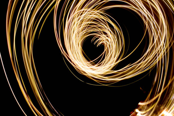 istock Abstract yellow light swirl on black background 1439476443