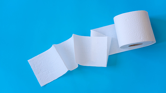 White toilet paper rolls on the blue background. Hygiene concept.
